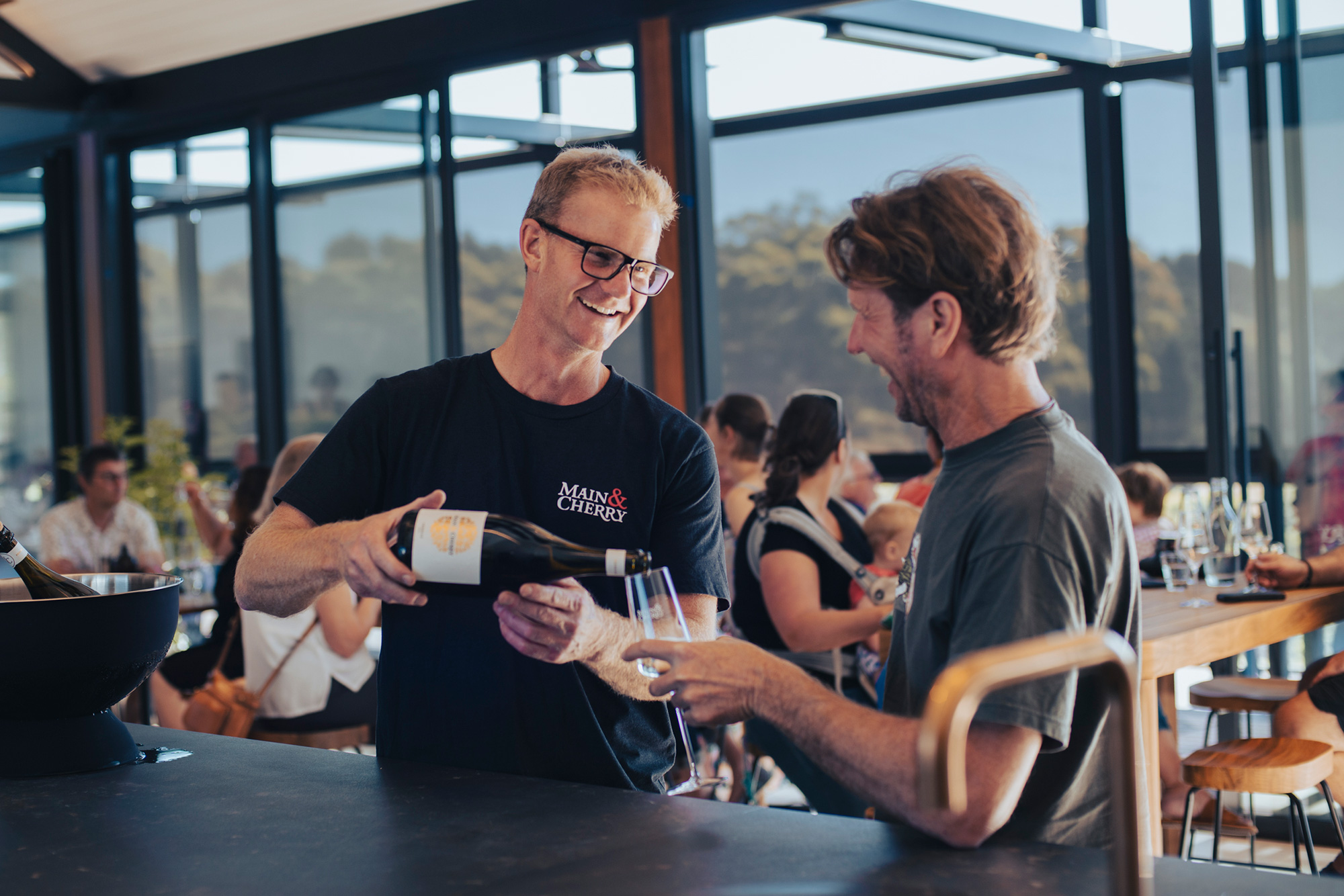 Owner and winemaker Michael Sexton pouring a glass of wine for a patron in the Main & Cherry cellar door.